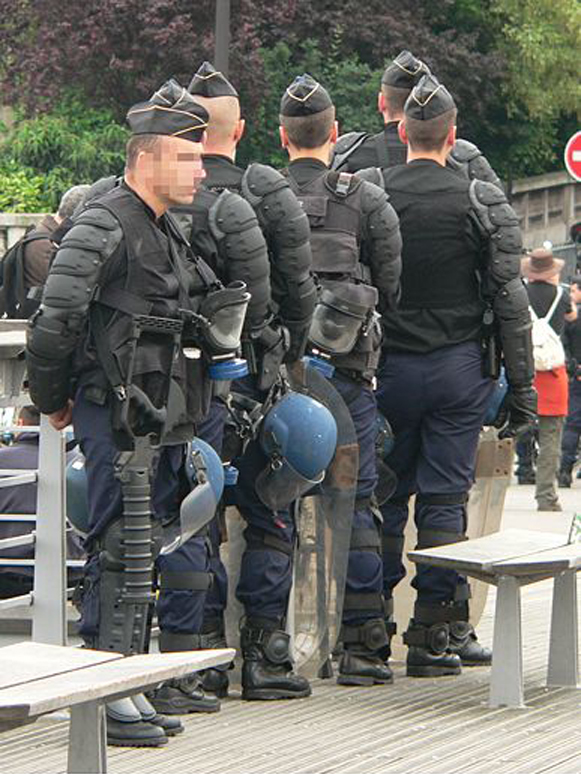 Gendarmes mobiles en tenue de maintien de l'ordre : gilets de protection, casques, masque à gaz et lanceur « flashball »